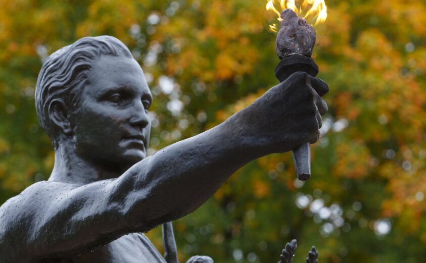 Torchbearer statue with fall leaves