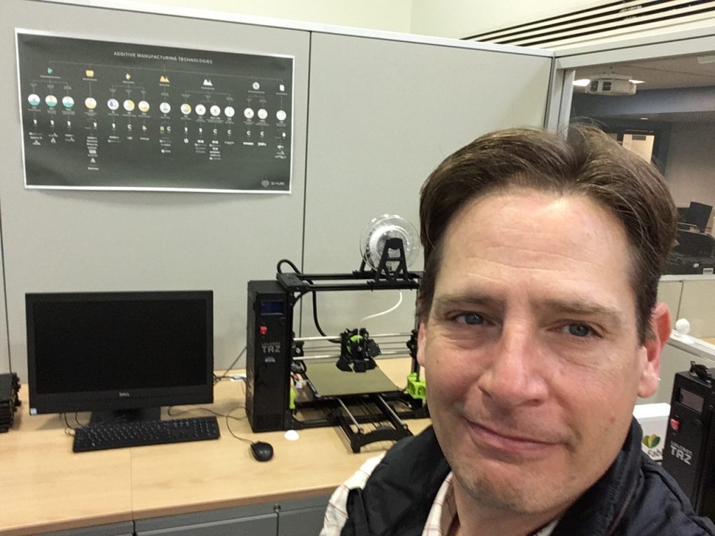 Image of Richard Sexton sitting in front of 3D Printer at Pendergrass Library