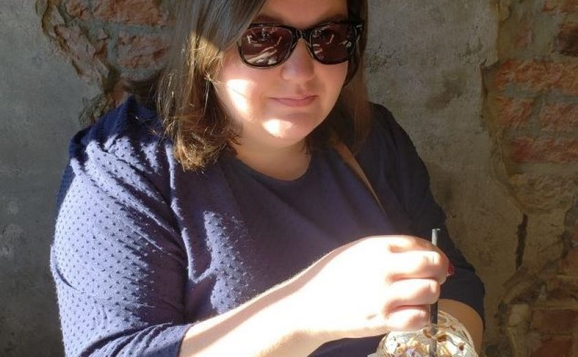 Image of Samantha Ward, wearing sunglasses and holding coffee