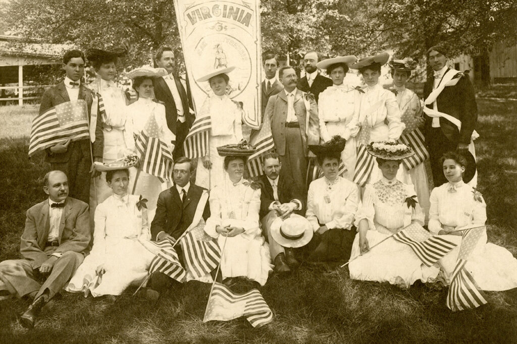 Summer School of the South, Fourth of July, Knoxville, Tenn., 1902. Ladies and gentlemen dressed in their finest and holding American flags.