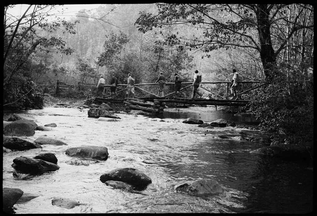 Hikers crossing a footbridge, Ridge Gregory Ridge trail (Herbert M. Webster Photograph Collection, UT Libraries)